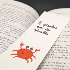 un marque page avec un crabe et un message "à prendre avec des pincettes"