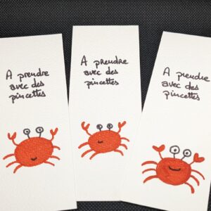 un marque page avec un crabe et un message "à prendre avec des pincettes"